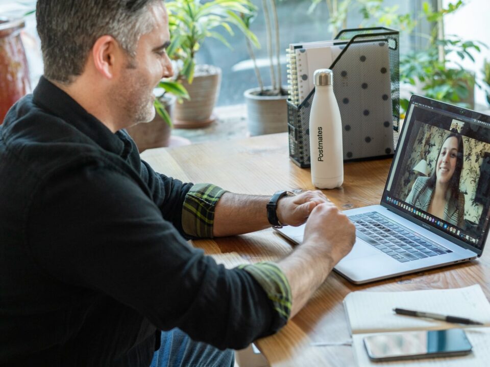 Adult male at a home desk on a video call with a therapist, illustrating what virtual cognitive rehabilitation therapy looks like