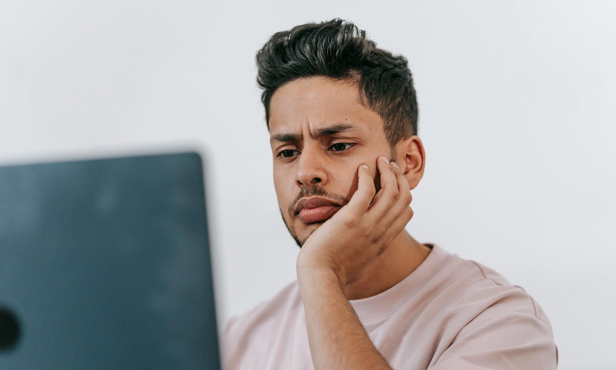 A man with a concerned expression looking at his laptop, reflecting the growing trend of people turning to AI tools like ChatGPT to research cognitive health symptoms.