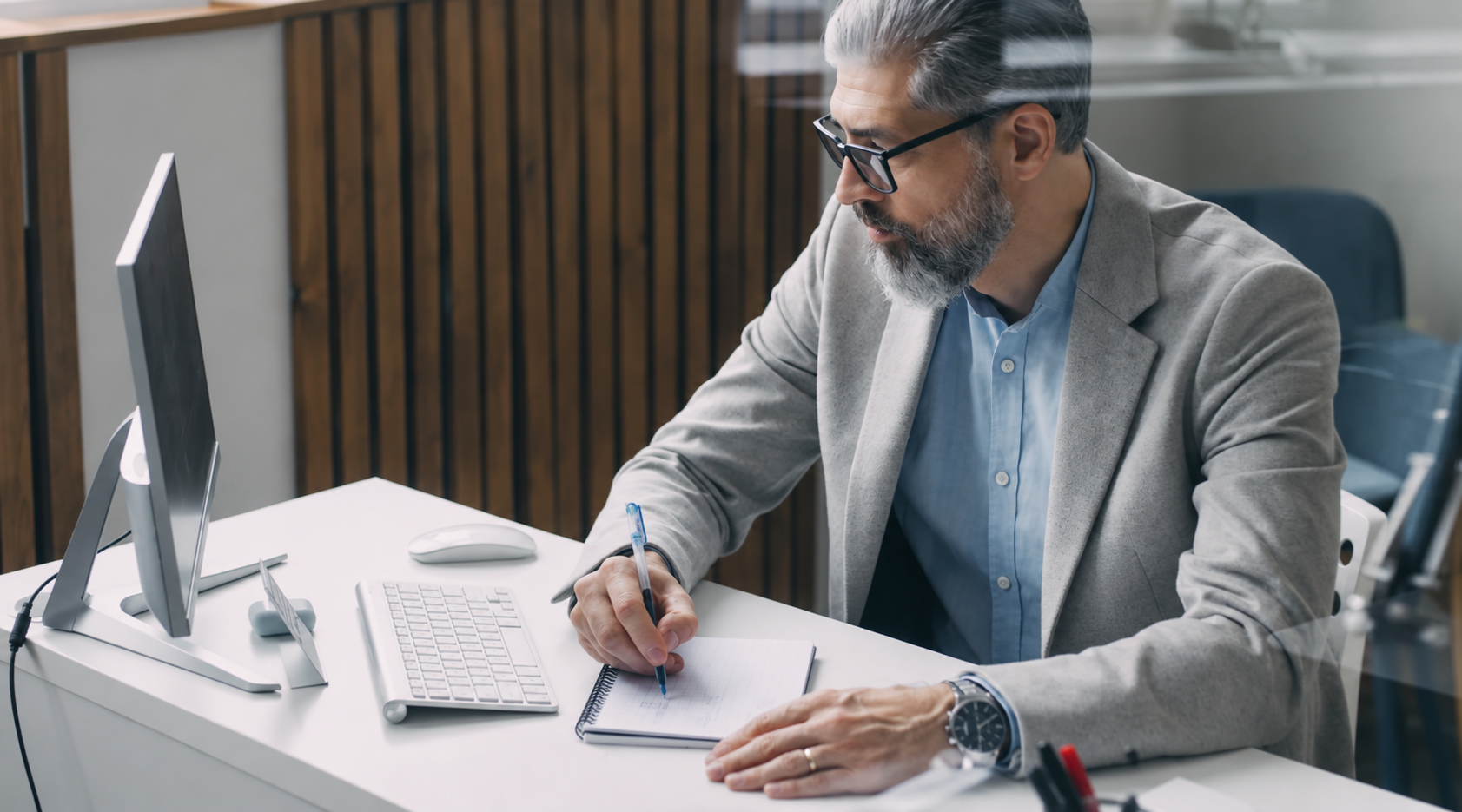 Professional reviewing notes at a computer while planning next steps